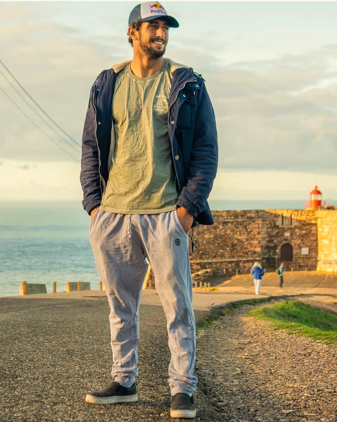 Lucas Chumbo, surfista patrocinado pelo Wave Itaúna, sorrindo diante do forte de Nazaré